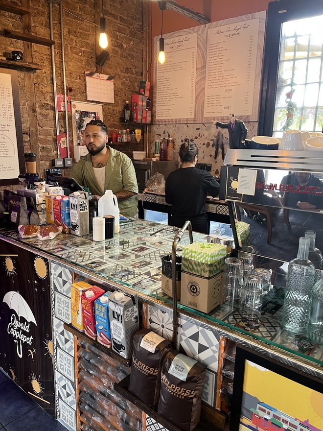 A barista behind the espresso bar in the exposed-brick interior